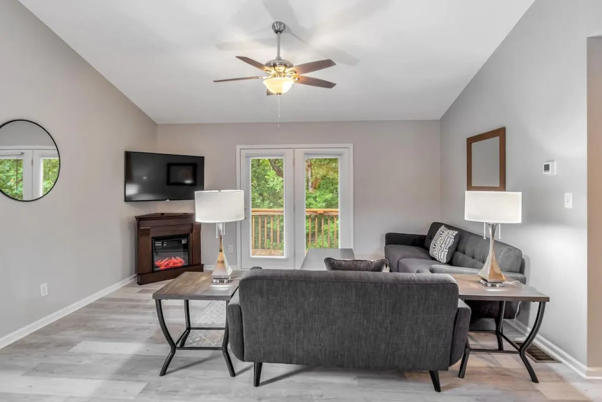 A bright, contemporary living area featuring a plush sofa, coffee table, and large windows that let in natural light. The room is arranged for socializing, with ample space for group gatherings and views outside, offering a welcoming environment for relaxing after exploring local nightlife.